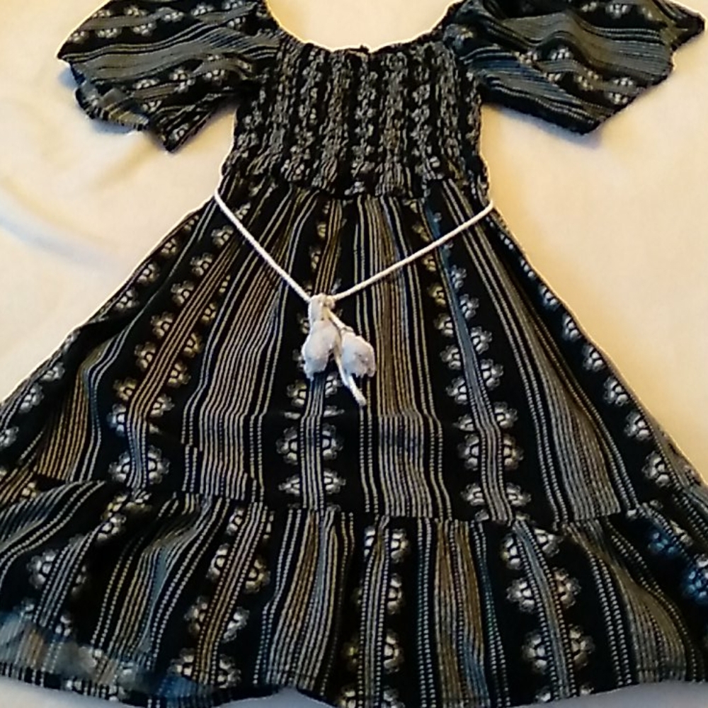 Patterned blackand white dress with white belt.